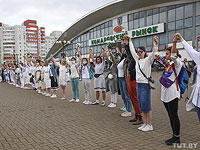 В Минске несколько сотен женщин в белой одежде и с цветами выстроились в длинную цепь