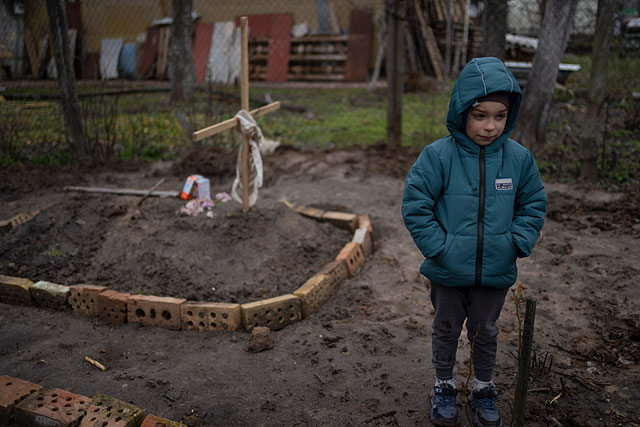 6-летний Влад Танюк во дворе своего дома возле могилы своей матери Марины, окраина Киева, 4 апреля 2022 года 6-летний Влад Танюк во дворе своего дома возле могилы своей матери Марины, окраина Киева, 4 апреля 2022 года