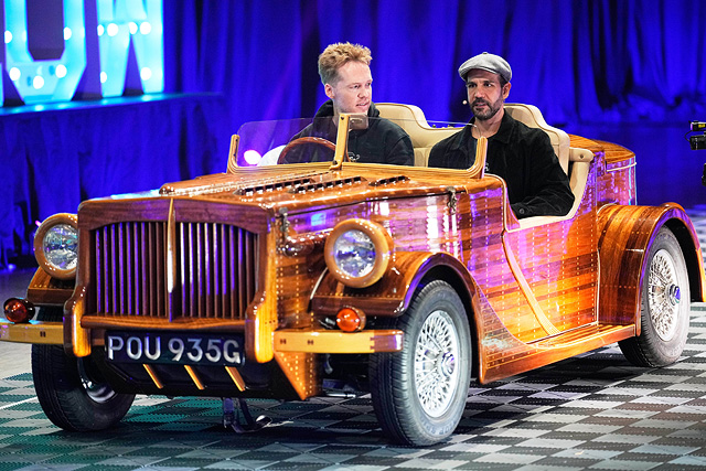 Люди сидят в изготовленном на заказ историческом британском автомобиле с шасси из красного дерева в форме лодки Riva 1969. Эссен, Германия Люди сидят в изготовленном на заказ историческом британском автомобиле с шасси из красного дерева в форме лодки Riva 1969. Эссен, Германия