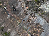 Сотрудник парка рядом с окаменевшими следами динозавров в районе Каррерас Пампа в национальном парке Торо-Торо, к северу от Потоси, Боливия Сотрудник парка рядом с окаменевшими следами динозавров в районе Каррерас Пампа в национальном парке Торо-Торо, к северу от Потоси, Боливия